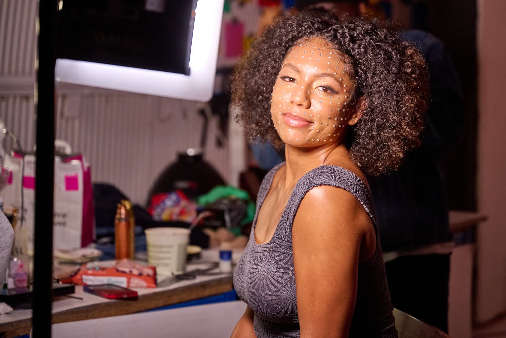 female singer getting jewelled makeup applied