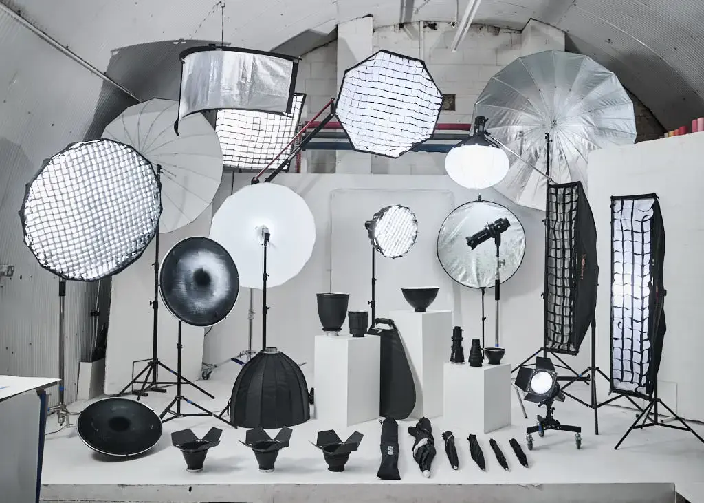 A large variety of studio lighting modifiers arranged in a photography studio